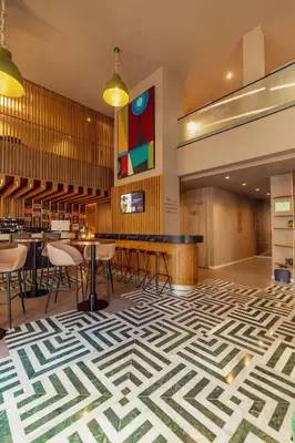 a lobby with a geometric patterned floor and tables and chairs at Le Square By Onomo Collection in Casablanca