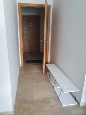 a hallway with a bench in front of a door at Superbe Appartement pieds dans l'eau Résidence Garden Bay in Sidi Rahal