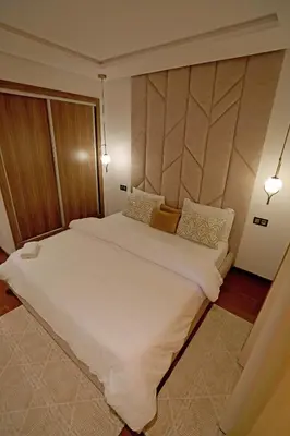 a large white bed in a room with two lights at 2 Luxury BD apartment Near of Rabat Agdal Station in Rabat