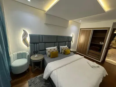a bedroom with a large bed and a chair at 2 Luxury BD apartment Near of Rabat Agdal Station in Rabat