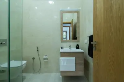 a bathroom with a sink and a toilet and a mirror at Appartement avec Piscine Proche Plage in Bouznika
