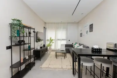 a living room with a couch and a table at Appartement cosy et moderne Bouskoura proche Aéroport et Hopital universitaire in Bouskoura