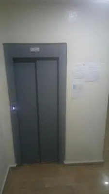 a green door in a room with a wall at best location single room in Casablanca