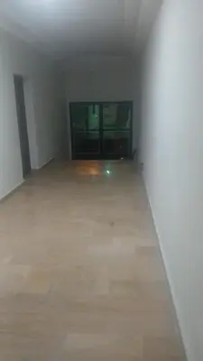 an empty room with a wooden floor and two windows at best location single room in Casablanca