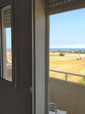 a room with a window with a view of a field at Appartement neuf tres calme balcon vue sur l'océan in Skhirat