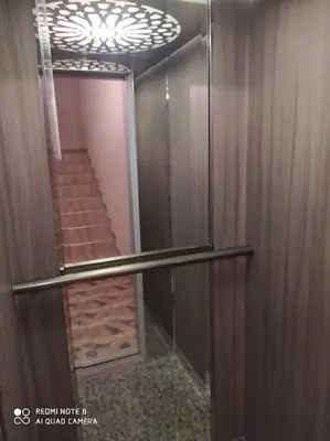 a elevator with a glass door and stairs in a building at Appartement neuf tres calme balcon vue sur l'océan in Skhirat