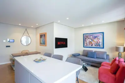 a living room with a red chair and a couch at Résidence Luxuria - Rooftop Pool in Casablanca