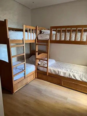 a room with two bunk beds and a ladder at Sidi Rahal Front mer, piscine & accès direct plage in Dar Oulad Hajj Kassem