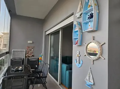 a room with a balcony with a table and chairs at Sidi Rahal Front mer, piscine & accès direct plage in Dar Oulad Hajj Kassem