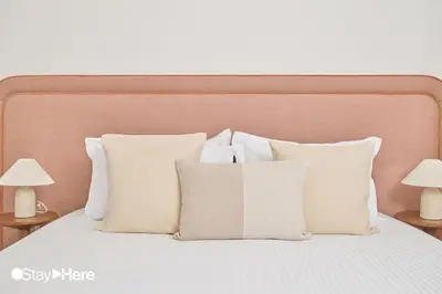a bed with white pillows and two lamps on tables at StayHere Casablanca - Oasis - Premium Residence in Casablanca