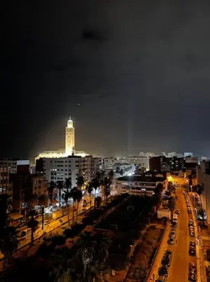 a city at night with a clock tower in the background at Sunset Lover in Casablanca-Port