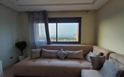 a living room with a couch and a window at Appart chic vue Mer in Casablanca