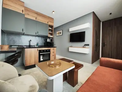 a living room with a table and a kitchen at Studio Palmiers Maarif in Casablanca