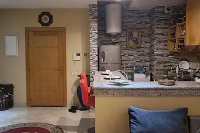 a kitchen with a counter and a refrigerator and a door at Suite Meublée à Nouaceur in Nouaceur