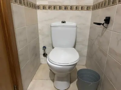 a bathroom with a white toilet and a trash can at Appartement moderne 2 chambres avec parking Agdal in Rabat
