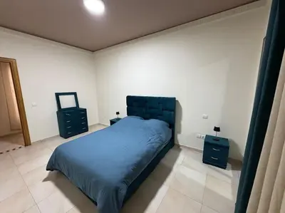 a bedroom with a bed and two night stands at Appartement moderne 2 chambres avec parking Agdal in Rabat