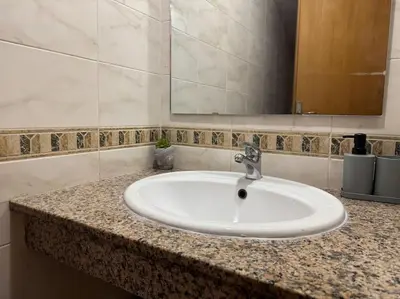 a bathroom counter with a sink and a mirror at Appartement moderne 2 chambres avec parking Agdal in Rabat