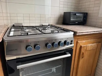 a stove top oven in a kitchen with a microwave at Appartement moderne 2 chambres avec parking Agdal in Rabat