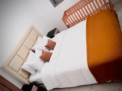 a bed with white sheets and pillows in a room at appartement neuf top quartier bouskoura a 2 min de l'Hôpital Universitaire International Mohammed 6 in Casablanca