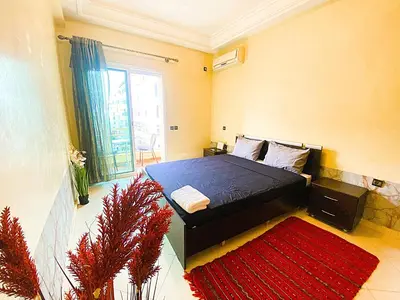 a bedroom with a bed and a red rug at Cosy calm 2BDR central near train & tramway in Casablanca