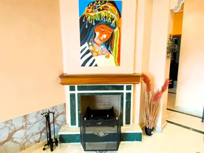 a painting above a fireplace in a living room at Cosy calm 2BDR central near train & tramway in Casablanca