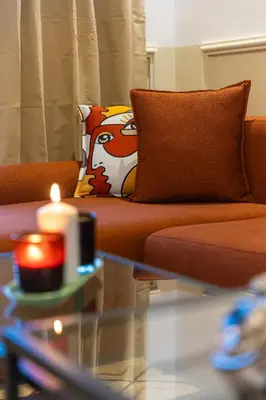a living room with a couch and a candle on a table at Stylish APPT 2 BDR Downtown of Rabat by MERAT HOME in Rabat
