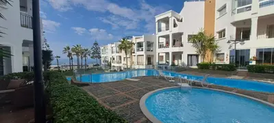 a swimming pool in front of a building at Appartement Beach House 2 Dar Bouazza in Dar Bouazza