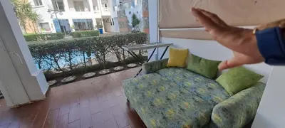 a hand reaches up to a couch in a living room at Appartement Beach House 2 Dar Bouazza in Dar Bouazza