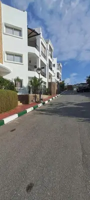 an empty street in front of a white building at Appartement Beach House 2 Dar Bouazza in Dar Bouazza