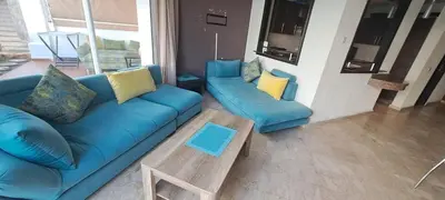 a living room with a blue couch and a coffee table at Appartement Beach House 2 Dar Bouazza in Dar Bouazza