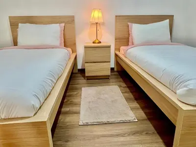 two twin beds in a room with a lamp at M océan in Mohammedia