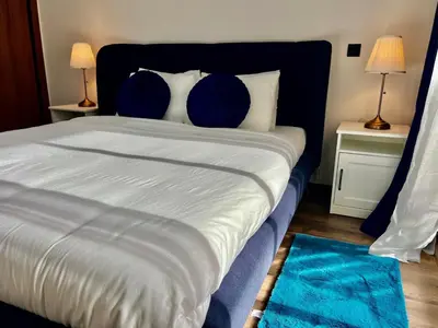 a bedroom with a large bed with blue pillows at M océan in Mohammedia