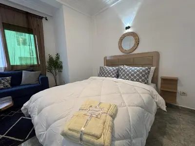 a bedroom with a large bed and a blue couch at appartement pour les familles , couples mariés bien meublé à Rabat in Rabat
