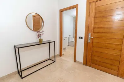 a hallway with a mirror and a table and a door at Maarif 6TH Floor with 3 Bedrooms - AppartAli in Casablanca