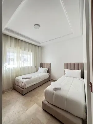 a bedroom with two beds and a window at SUITOUISS - Agdal 4 - Appartements à 2 minutes de la gare de train TGV Rabat in Rabat