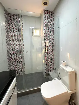a bathroom with a toilet and a glass shower at SUITOUISS - Agdal 4 - Appartements à 2 minutes de la gare de train TGV Rabat in Rabat