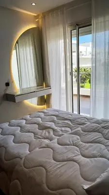 a large bed in a bedroom with a large mirror at Seaside studio with pool in Dar Bouazza