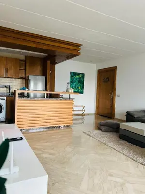 a large living room with a counter and a kitchen at Seaside studio with pool in Dar Bouazza
