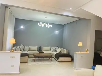 a living room with a couch and a table at villa azur in Dar Bouazza