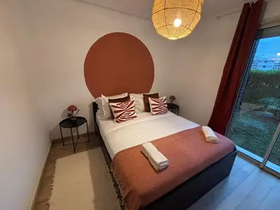 a bedroom with a bed with a large window at Bouskoura, appart jardin privé in Casablanca