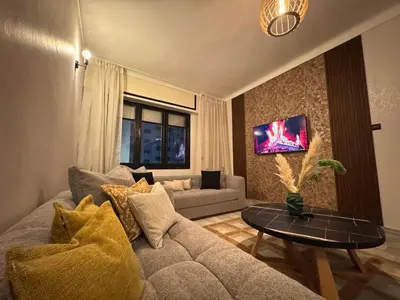 a living room with a couch and a table at Appartement de luxe 155m agdal centre in Rabat