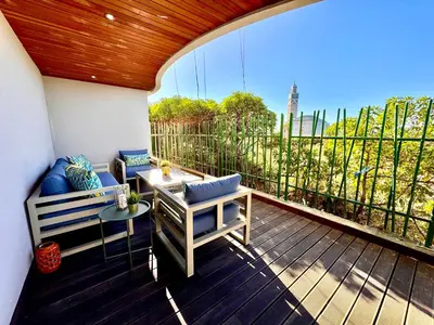 a patio with a table and a bench on a deck at Duplex de luxe avec jardin au coeur de la marina in Casablanca
