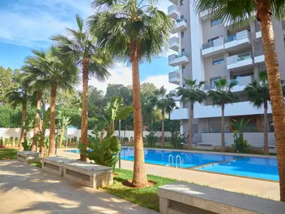 a hotel with palm trees and a swimming pool at Nexthouse in Casablanca