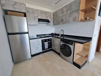 a kitchen with a stainless steel refrigerator and a dishwasher at Anchor point in Dar Bouazza