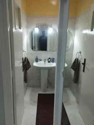 a man taking a picture of a bathroom with a sink at Appartement au centre de Rabat Agdal in Rabat