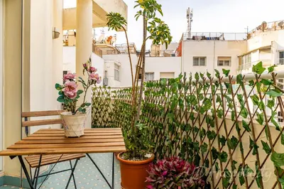 a balcony with a wooden table and potted plants at Gauthier 5-Star Luxury Gem in Casablanca