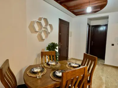 a dining room with a wooden table and chairs at Appartement exceptionnel en plein centre de rabat pour les familles et couples mariés in Rabat