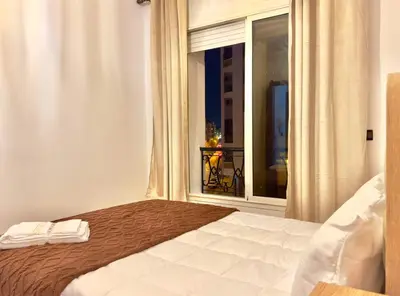 a bedroom with a bed and a large window at Appartement exceptionnel en plein centre de rabat pour les familles et couples mariés in Rabat