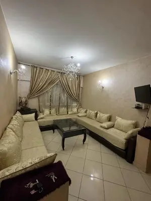 a living room with a couch and a chandelier at Appartement à Ain Sebaa proche de tous les commodites in Casablanca