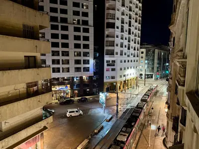 a view of a city street at night with a white car at Casablanca Central Suites - Casa Port in Casablanca